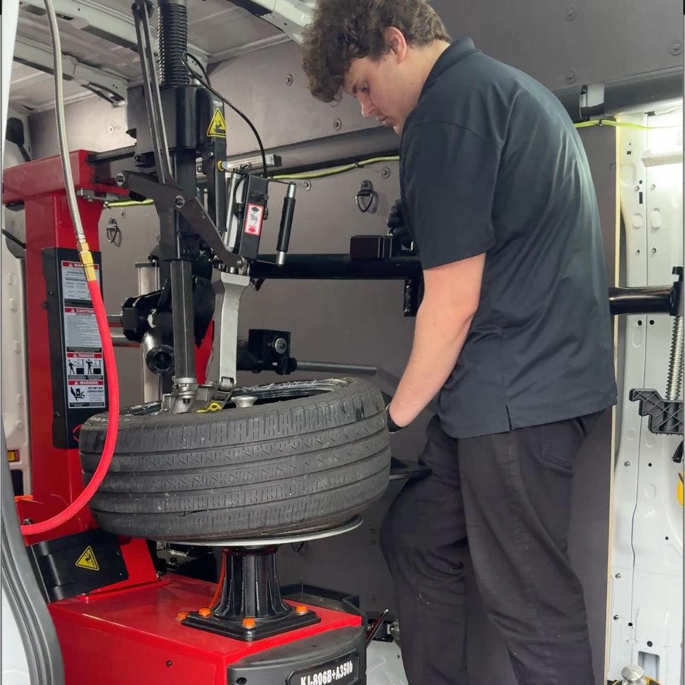 Technician performing an off-rim tire change using professional equipment in North Vancouver