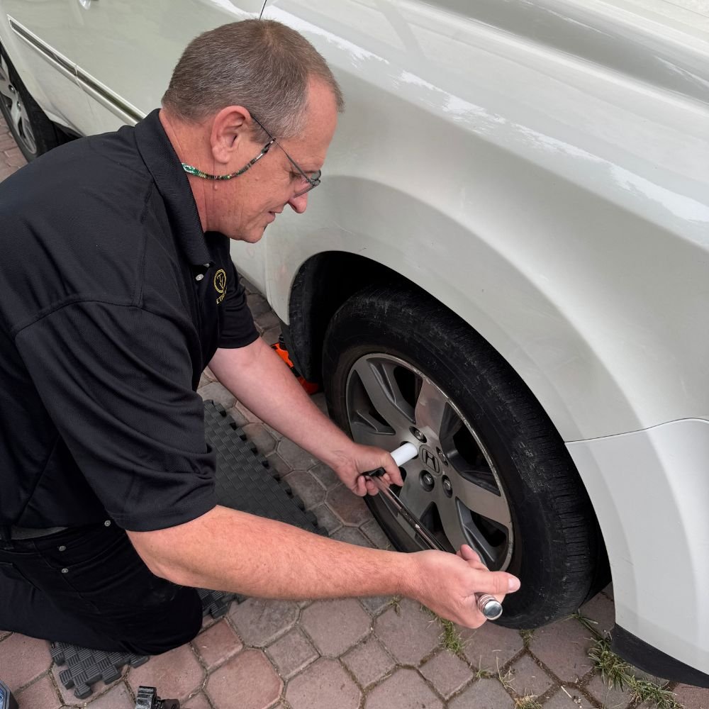 Technician performing an on-rim tire change and torque check at a home in West Vancouver